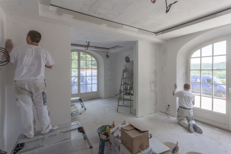 Drei Handwerker bei der Renovierung eines Zimmers