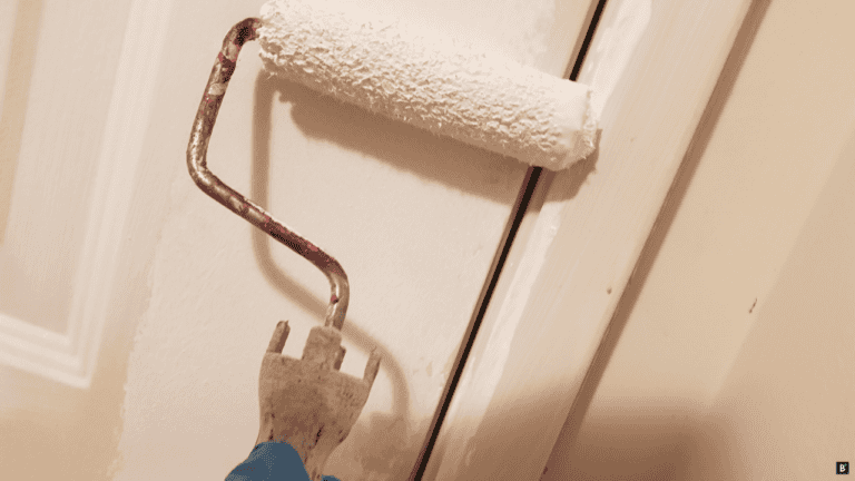 Mit einer Rolle wird eine Tür gestrichen