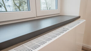 Ein Plattenheizkörper unter einer Fensterbank