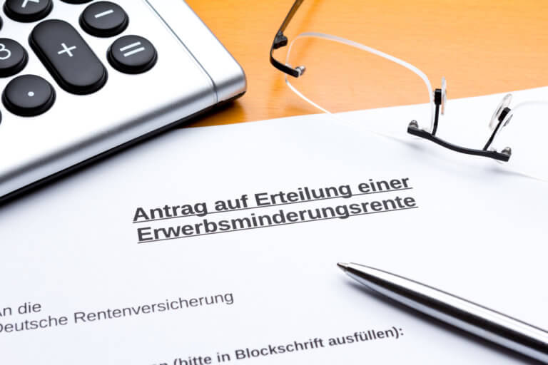 Taschenrechner, Kugelschreiber und Brille liegen neben einem Antrag auf Erwerbsminderungsrente
