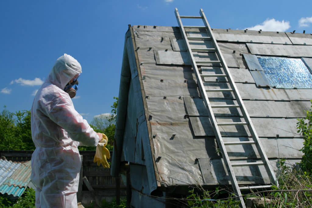 Mann bereitet die Asbestsanierung eines Daches vor.