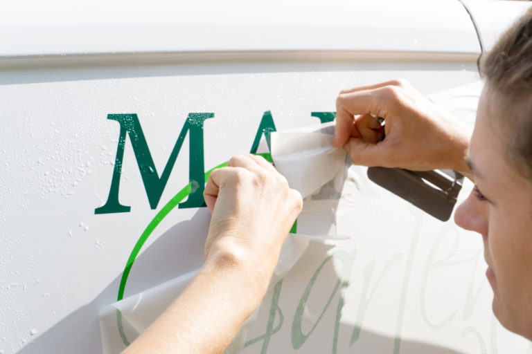 Beschrifteter Firmenwagen mit Fahrzeugwerbung eines Handwerksbetriebs