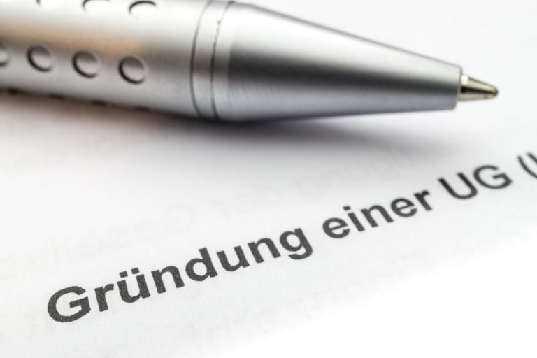 Gründer unterzeichnen Unterlagen zur UG-Gründung