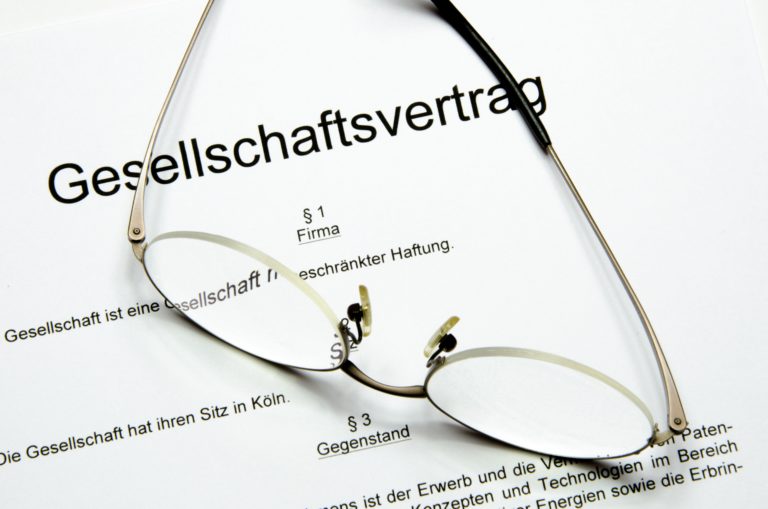 Geschäftsleute unterzeichnen Unterlagen zur GmbH-Gründung