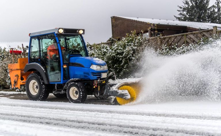 Räumfahrzeug entfernt Schnee von einem Gehweg