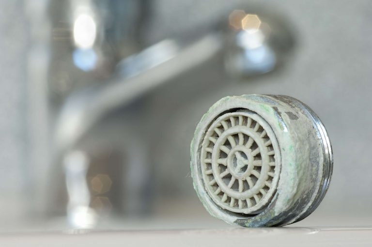 Verkalkter Perlator eines Wasserhahns.