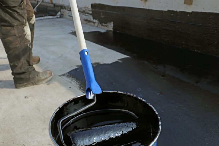 Handwerker bei der Flachdachsanierung mit Bitumen