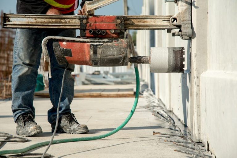 Bauarbeiter bei einer Kernbohrung an einer Betonwand