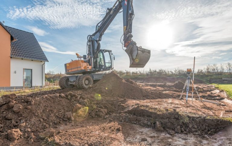 Bagger hebt eine Baugrube für ein Haus aus
