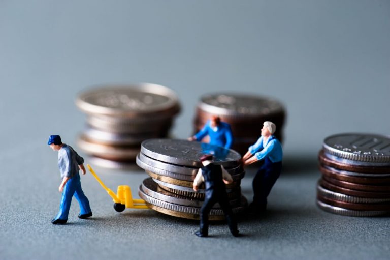 Unternehmer berechnet Gewerbesteuer mit Taschenrechner und Unterlagen