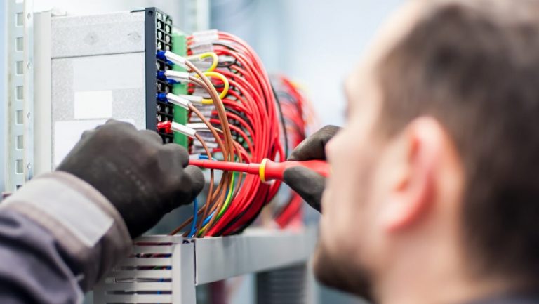 Elektriker mit Schraubendreher bei der Arbeit