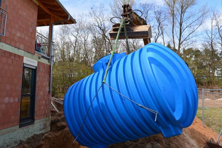 Eine blaue Zisterne wird eingebaut