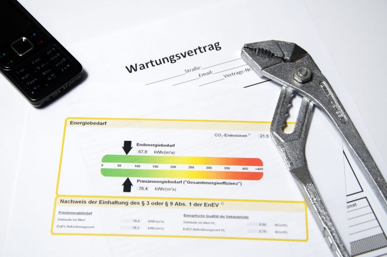 Ein Wartungsvertrag mit Energielabel, Zange und Handy.