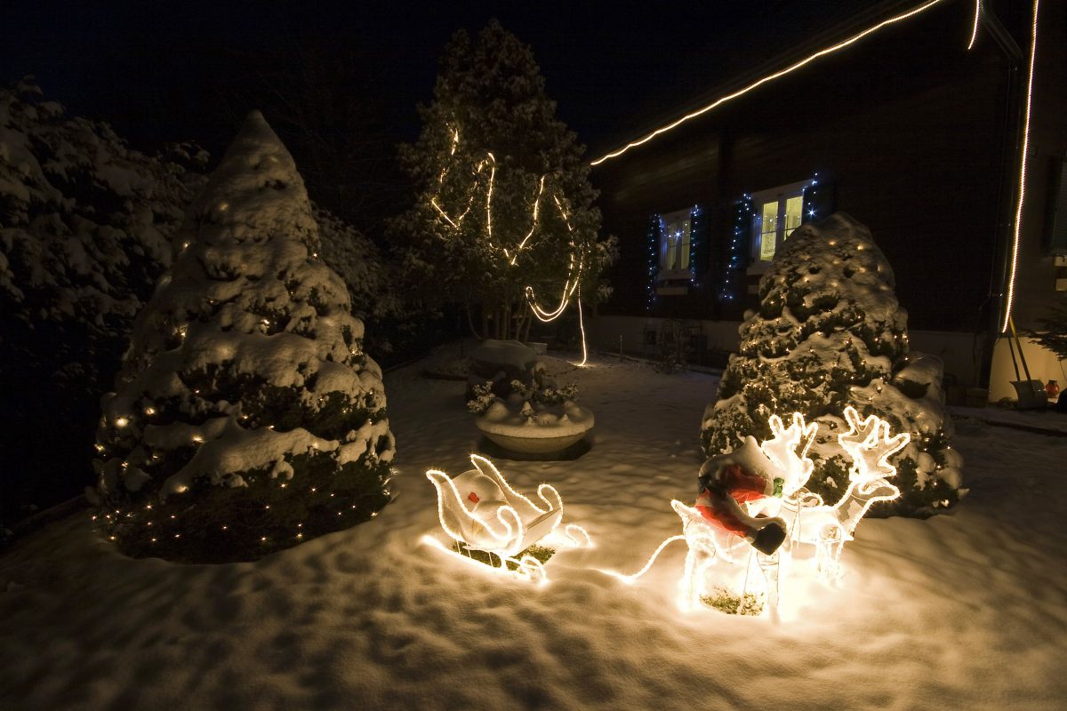 Weihnachtliche Gartenbeleuchtung mit Schlitten und Rentieren.