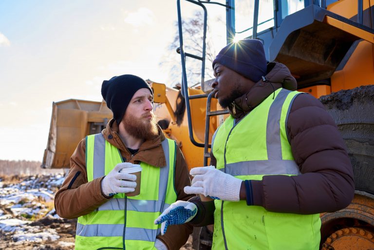 Zwei Bauarbeiter tragen Schutzkleidung, um Arbeitsschutz im Winter zu garantieren.