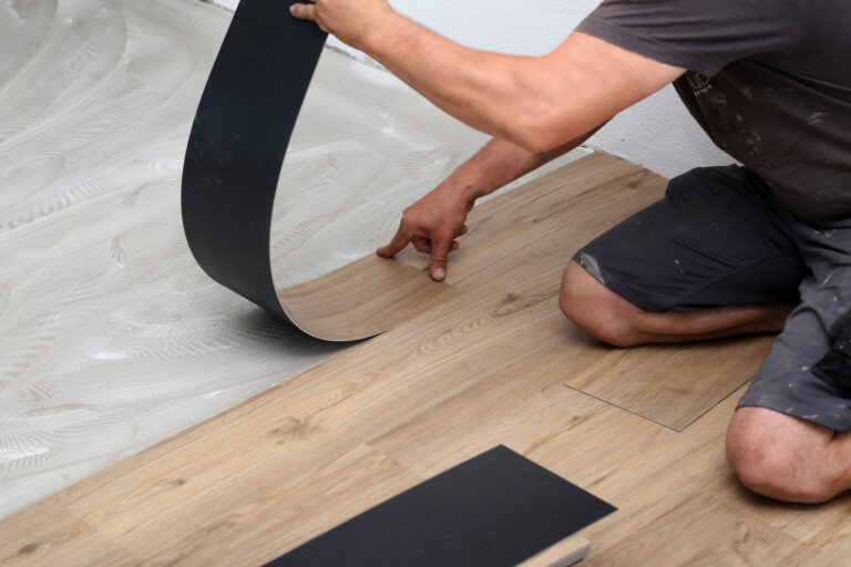 Handwerker beim Vinylboden verlegen.