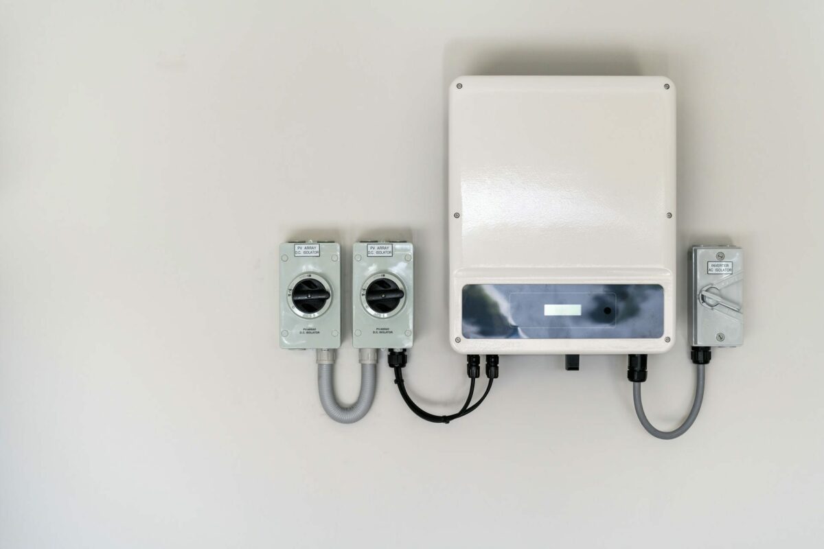 Wechselrichter auf einer weißen Wand montiert. Weißer Kasten mit einigen Kabeln