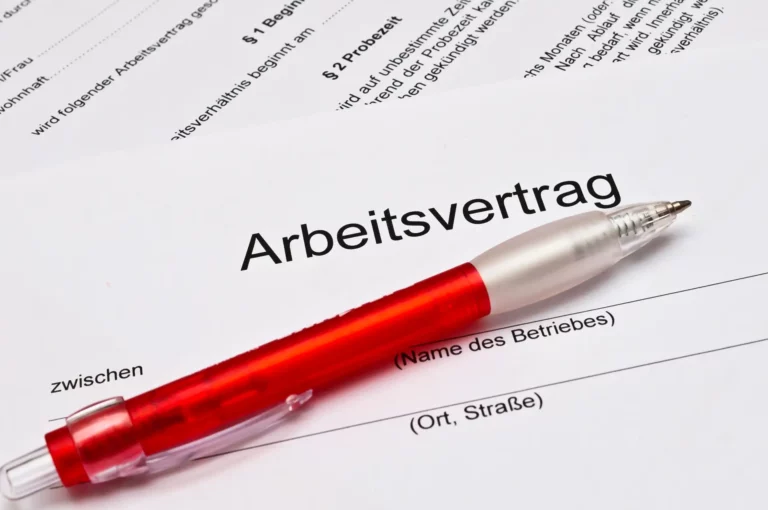 Roter Kugelschreiber liegt auf einem Arbeitsvertrag