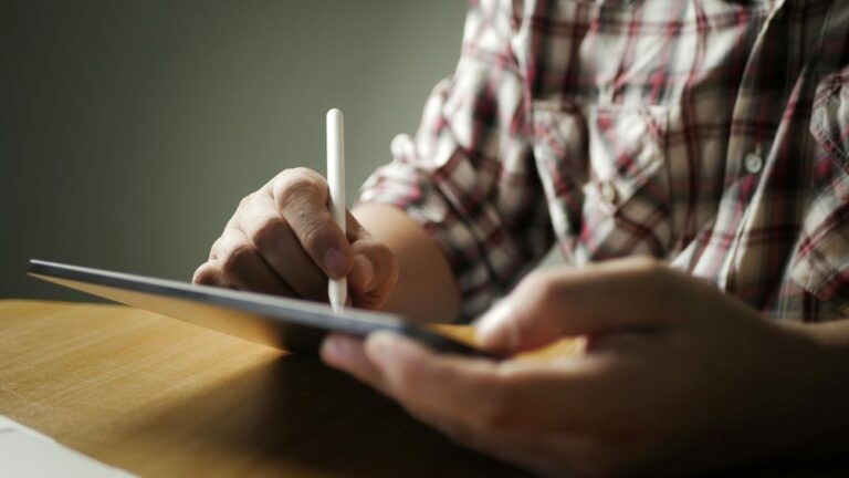 Handwerker schreibt etwas auf einem Tablet