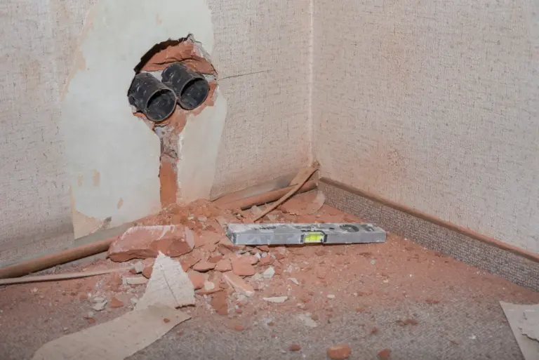 Handwerker beseitigt Baustellenschmutz nach der Arbeit