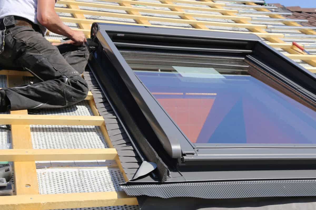 Ein Dachfenster wird von einem Handwerker eingebaut