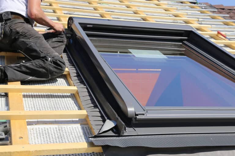 Ein Dachfenster wird von einem Handwerker eingebaut