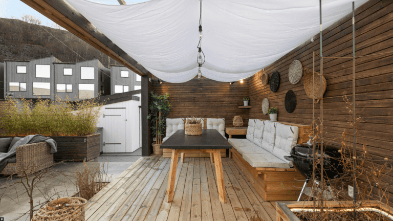 Holzterrasse vor Holzwand mit Möbeln