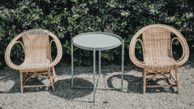Zwei Rattanstühle und ein Beistelltisch auf Kies