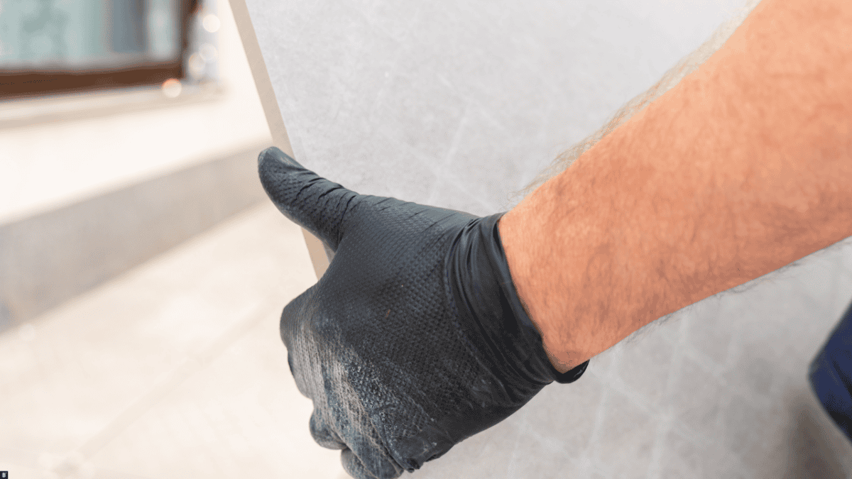 Man sieht wie eine Terrassenplatte Richtung Terrasse getragen wird