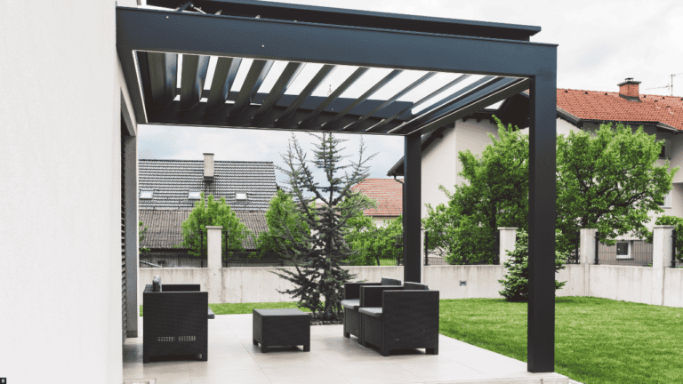 Eine schwarze Terrassenüberdachung aus Aluminium auf einer Terrasse mit schwarzen Möbeln