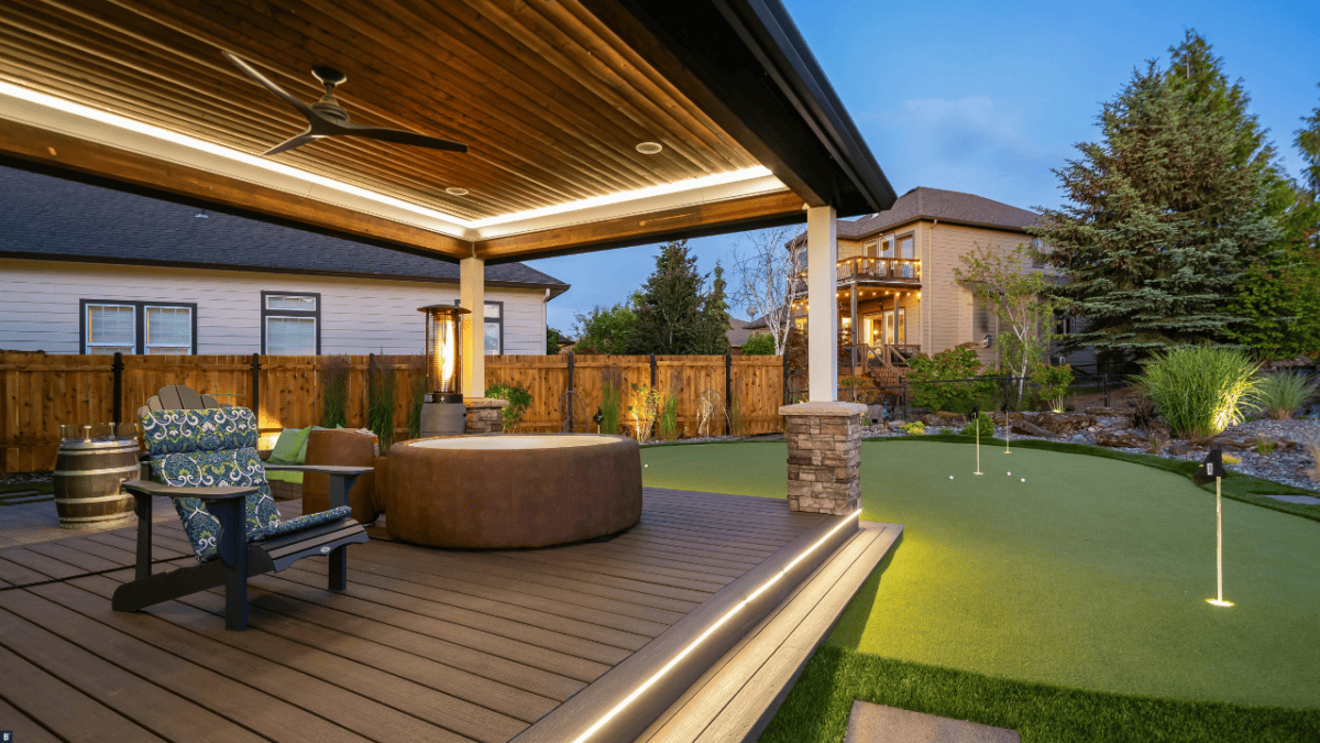 Eine mit LED Lichtbändern verzierte Terrasse mit WPC Dielen und kleinem Golfplatz