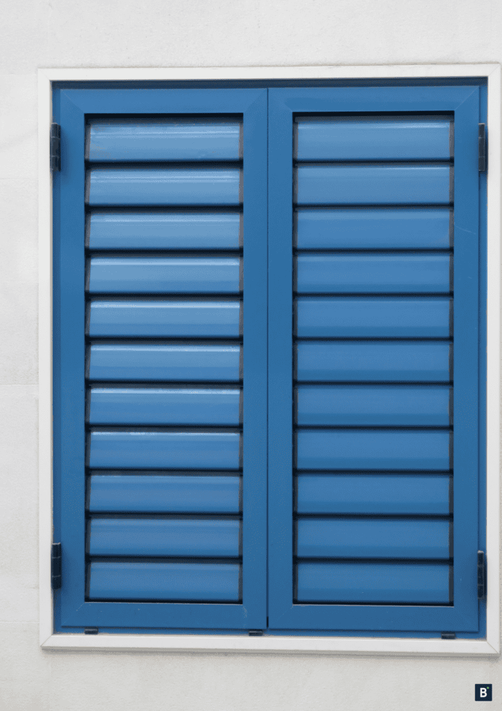 Blaue, geschlossene Fensterläden auf weißem Putz.
