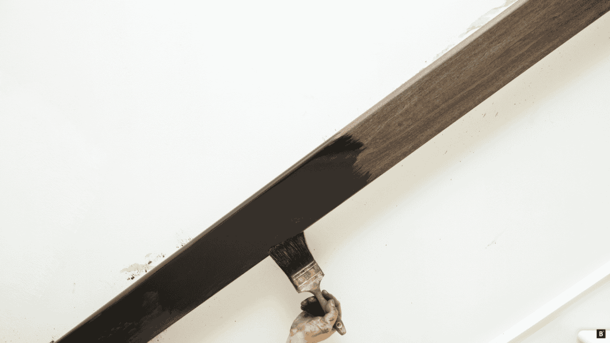 Ein Holzhandlauf wird gestrichen