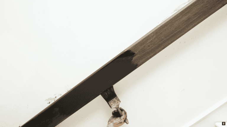 Ein Holzhandlauf wird gestrichen