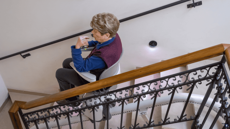 Frau sitzt auf einem Treppenlift