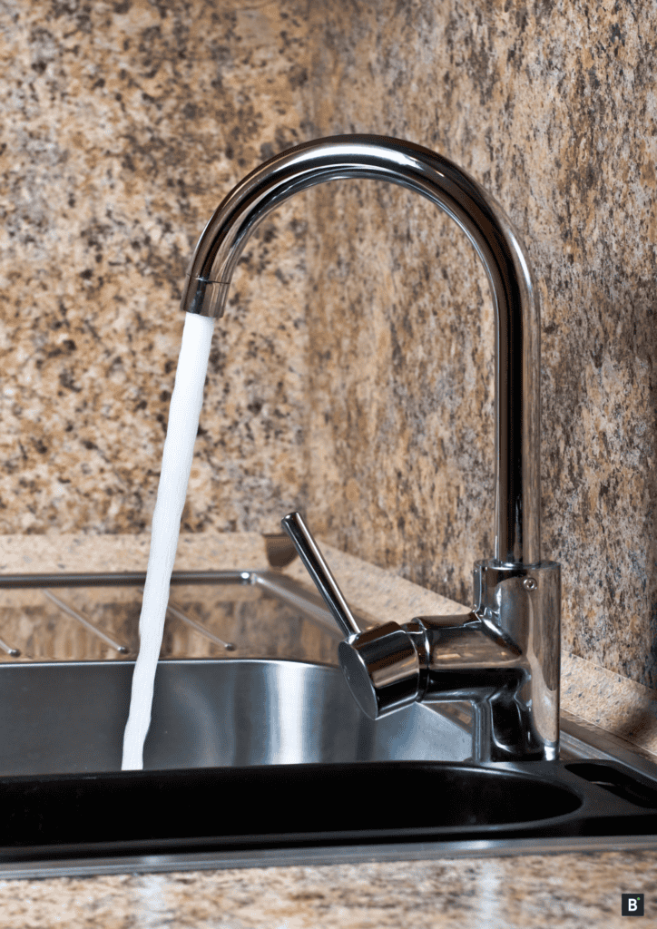 Wasserhahn mit Edelstahlwaschbecken und Granit Arbeitsfläche und Spritzschutz