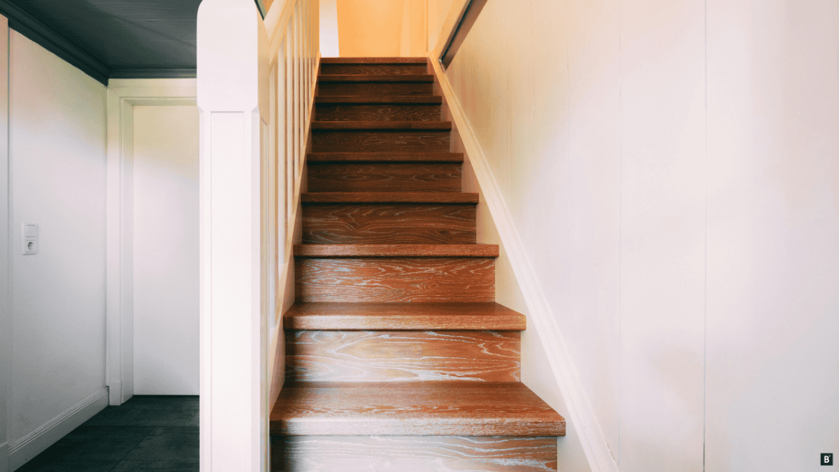Eine Holztreppe mit weißen Geländer