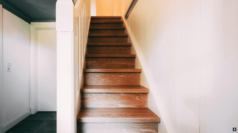 Eine Holztreppe mit weißen Geländer